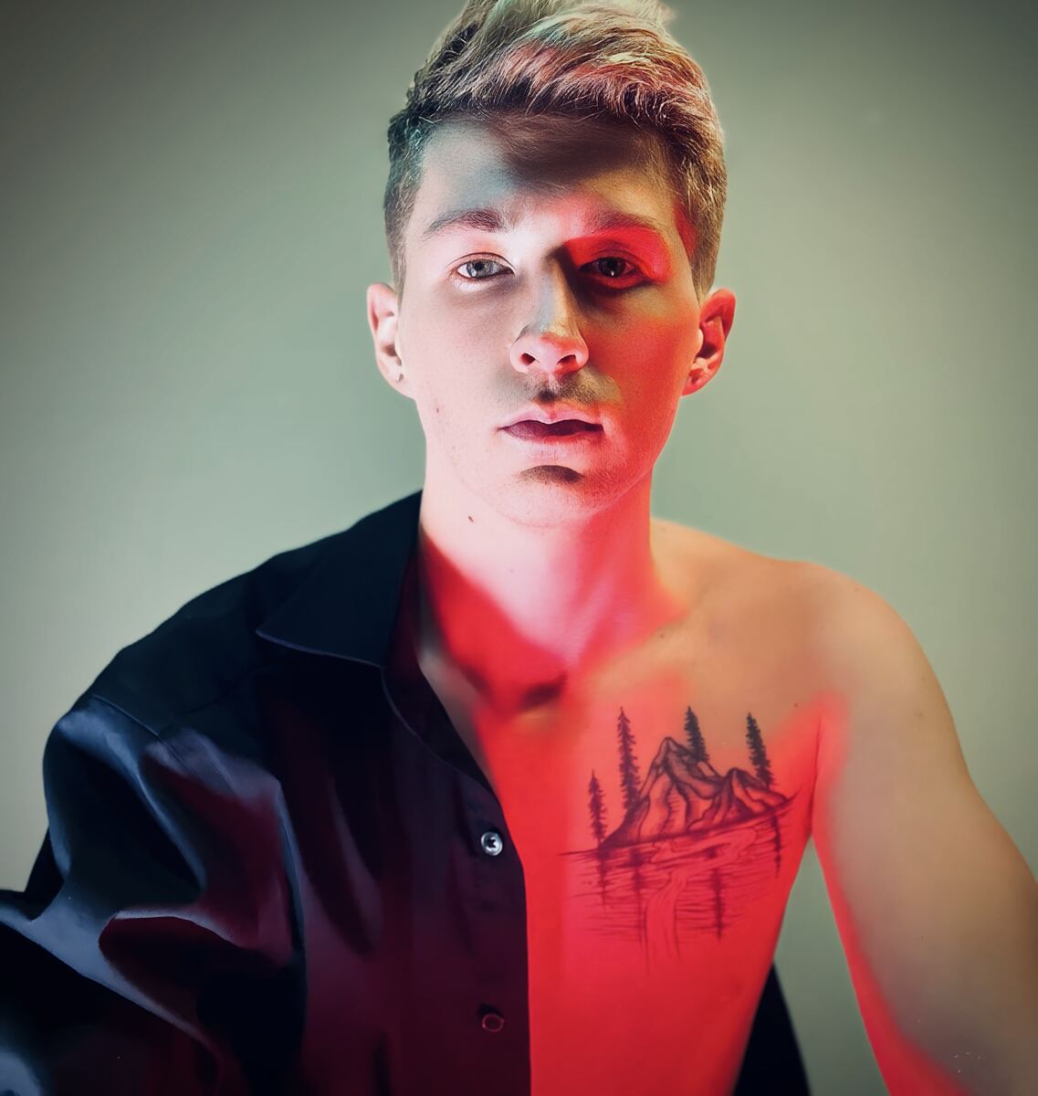 Ethan David, half-lit in red, looking into camera